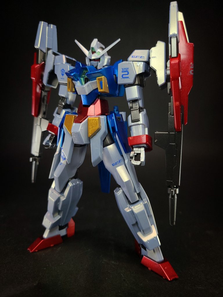 本来、Xラウンダー専用機として開発されていたAGE-2を非Xラウンダーパイロットであるアセム・アスノの専用機として運用するよう方針を変更した結果として生まれた機体でもあり、二刀流のような両手に武器を持った戦い方を好むアセムの戦闘スタイルに合わせつつ彼の卓越した直感力や反射神経を最大限に発揮させる為の装備という側面も持っている。更に対Xラウンダー用のウェアとしての運用も考慮されていて、ゼイドラやクロノスとの戦闘データも活用された。