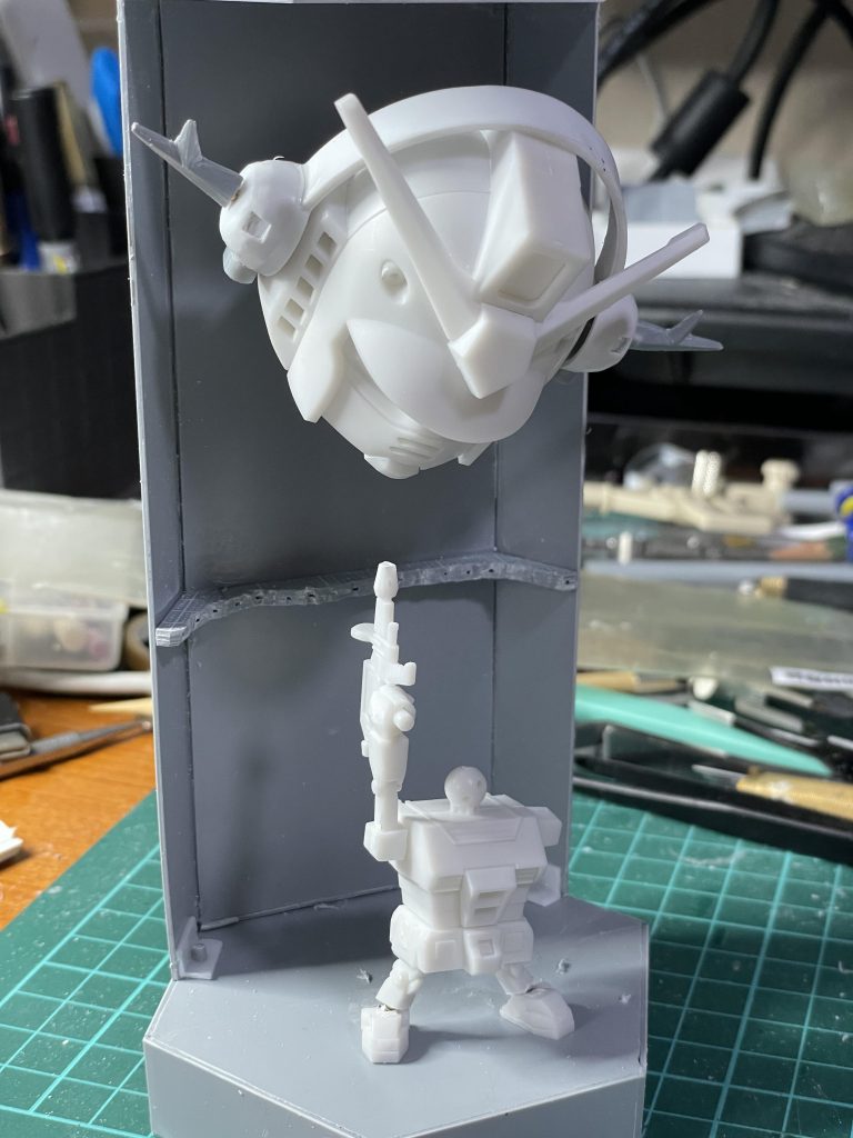 スタンスを広く取れるように、足首を切り離してボールジョイント化しています。ボールは直径約3mmのビーズを使用しました。左腕は肩アーマーの下で切り離して、1.5mm径真鍮線でつけ外しできるようにしてます。ジオングヘッドフォンにはプラ板等の他にSDCSダブルオーダイバーのGNドライブ(コーン型)を使いました。ネオジム磁石でガンプラくんの頭にくっつきます。