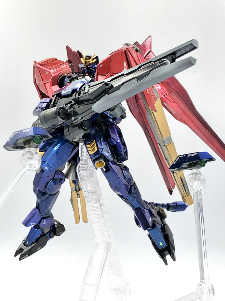 メイン武器の大型ビームライフルは砲身に可変機構を搭載しており、スナイパーモード/バスターモードの切り替えギミックを仕込みました。写真はスナイパーモードで、砲身は１つ前の写真の状態から両手持ち用のグリップを展開してスナらしいポーズが可能！脚部側面からユーラヴェン由来のカメラビットも展開し、狙撃能力を向上させられる設定です。