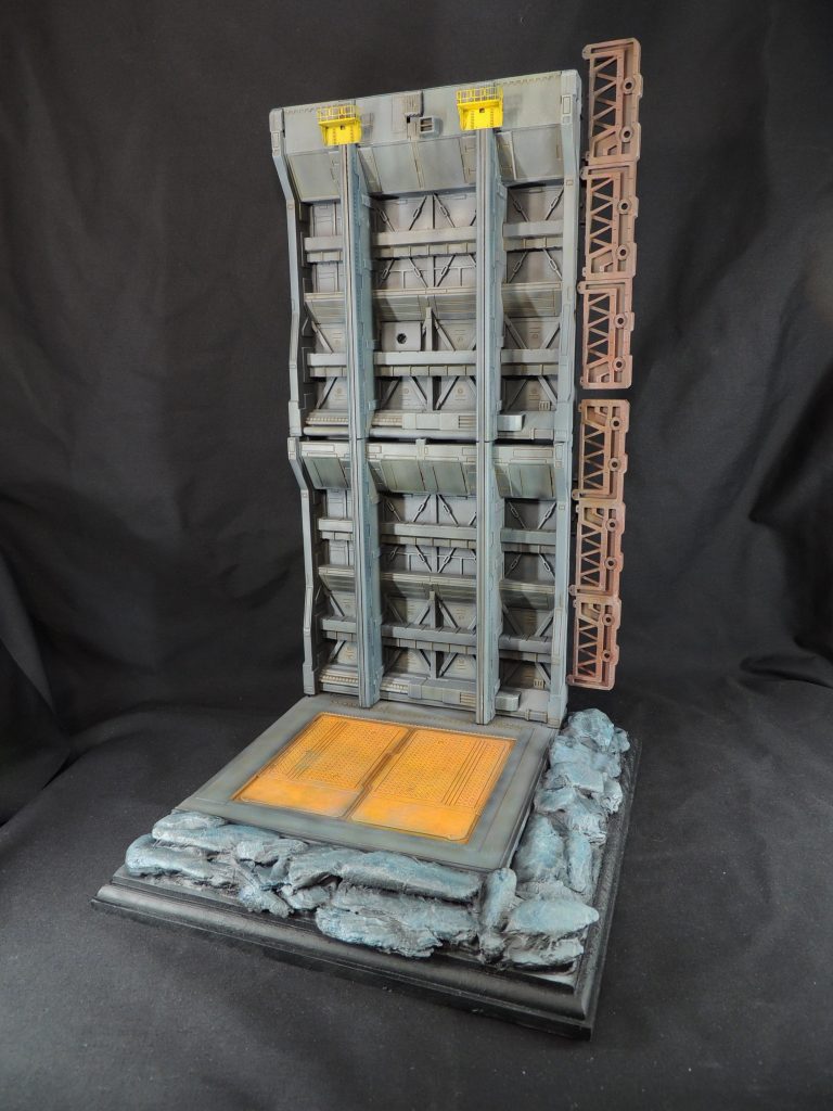 ベースは、市販のベースのキットを使用して、宇宙要塞ソロモンのドッキング・ベイの雰囲気を想像して製作しました。手前の岩石は100円ショップで入手したインテリア・バークを敷き詰めています。リック・ドムとシン・マツナガ・ザクは、フィギュア用の半透明の支柱で中空に固定することにしました。