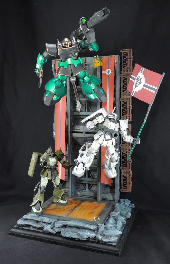 МSたちの巨大感を演出するために、ビルダーズ・パーツを改造したジオン兵のフィギュアを各所に配置して完成です。今回、たまたまドズル専用リックドムの資料に「宇宙世紀0079年末には観兵式に参加している。」という一文を見つけ、そこから想像力を発揮して情景を自分なりにジオラマ化してみました。自由な発想で製作でき、とても楽しい経験となりました。