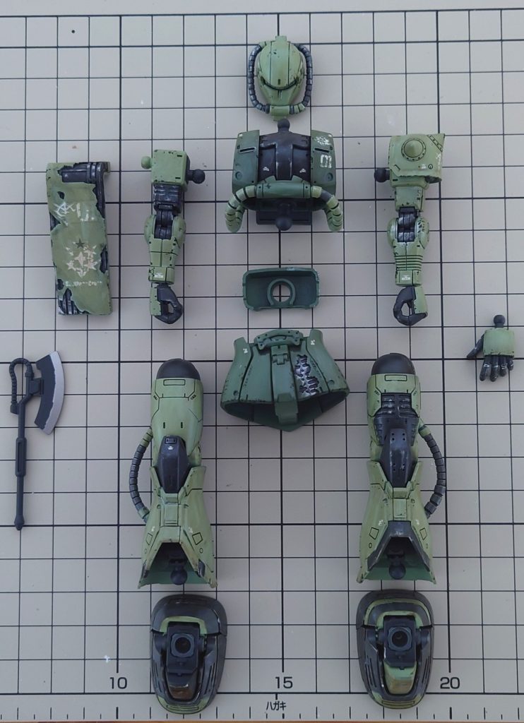 組み立て前の一枚。いつもの通りに作る工程に加え、今回はウェザリングを施しましたので、割と手間がかかりましたが、初ウェザリングにしては満足のいくものができました。今回使いました塗料や工程は以下の通りです。薄緑：MSグリーン濃緑：MSディープグリーン薄グレー：MSグレー　ジオン系濃グレー：ニュートラルグレー5下地・フレーム：メカサフ　スーパーヘヴィピンク（モノアイ）：蛍光ピンク①全パーツをメカサフで塗装後、シールド等の装甲剥がれの部分はマスキングゾルにてマスキング。②パイプ等の塗り分けは付属のシールでシールマスキング。③塗装完了後、光沢クリアーでスミ入れのふき取りやすくすると共に塗膜の保護④水転写式デカールの貼り付け後、半光沢のクリアーでデカールの保護⑤ウェザリングカラー　グランドブラウン　→　ウェザリングカラー　マルチブラック　→　エナメルホワイトの順番でウェザリング⑥エナメルシルバーでドライブラシ　→　エナメルブラックでチッピング　→　ウェザリングマスター　Aセットで土汚れを表現⑦つや消しクリアーで表面を保護して完成今回もご覧いただきありがとうございました！