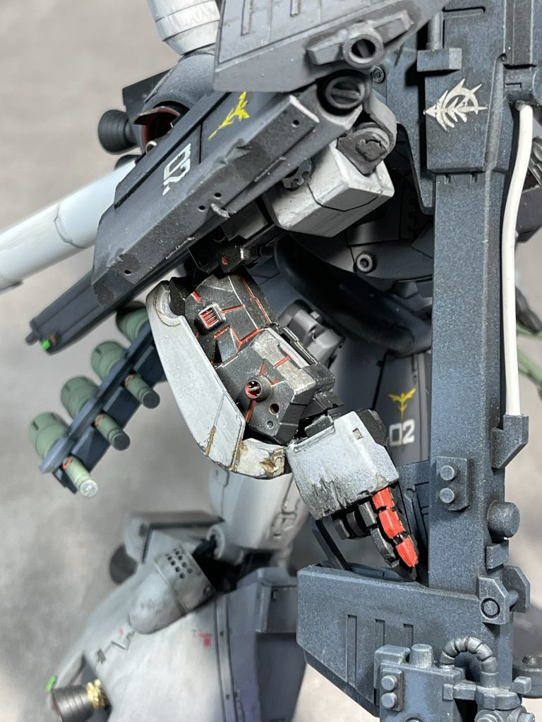 右肩シールドは基部で回転し、上部をはね上げることが可能。バズーカ保持の際干渉しないようになっています。 勿論、オリジナル機は内側も装着されていますが、この個体は戦闘による喪失なのか、可動域の空冷確保か、腕のムーバブルフレームには外側しか装甲がありません。 リアスカートには4連大型グレネードを装備。トリガーに指を掛けていない細かい仕草にもご注目。