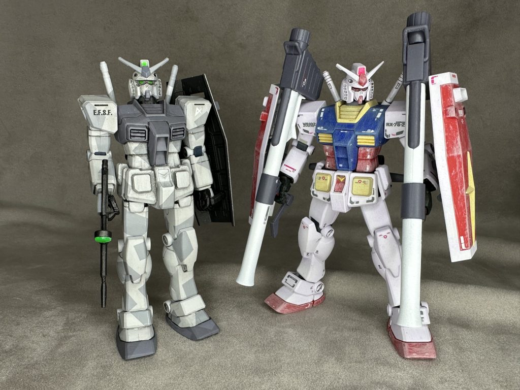 　今回組んだのは、HGUC Gアーマー付属の旧キットです。昔作ったGアーマーの中身が出てきたので、他グレードと作り比べてみました。基本的にどれも素組み（やや改修）です。　基本はHGUCの№021ですが、つま先が可動しA/Bパーツ分離可能なマイナーチェンジ版。全体のボディラインは旧PGからの流れを汲んで、力強いマッシブ体形。プレーンなRX-78が欲しかったので配色はそのまま。成形色に調色した近似色をドライブラシでエッジに乗せるという手法を使っています。ちなみにデカールはRG用をできるだけ使用してみました。あと手だけは純正品が我慢できず、MSハンドを例によって関節から切り離して変更し使用しています。　左側はFG、ファーストグレード。いわゆる300円ガンダム。モナカ構造のキットで、たぶん塗り分けが地獄です（笑）。今回は余っていたグレー塗料でスプリット迷彩なんちゃってＧ３仕様に全塗装。ラクをしましたｗ旧ＰＧデザインそのままをダウンサイジングしているので、体形はガッチリしています。が、可動は絶望的にしないので、基本棒立ちにしかなりません。関節を切り離して任意に固定、塗り分けをしっかりすれば今でも十分に通用するデザインだと思います。あと武器のビームライフルがペラペラなので他から流用しないと（苦笑）。