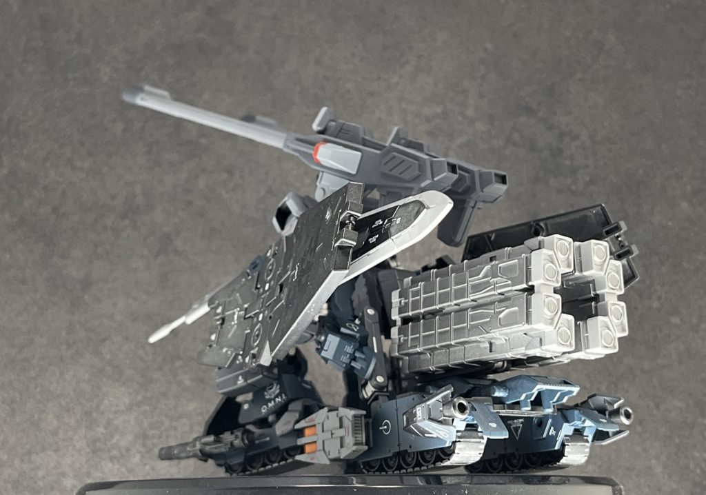 　下半身のクローラーユニットは、高速移動形態の「タンクモード」と凹凸地形対応形態の「ストライダーモード」の2形態がある。タンクモードは平地や砂漠地帯での高速移動を目的としている。一方のストライダーモードは瓦礫の山や、山の傾斜を登るためのものだが、一部装備をパージする必要があり、タンクモードに戻ることができなくなる欠点を有する。　元々はガルナハン基地のローエングリン砲台の防衛を目的として配備される予定だったが、連合の新型MAゲルズゲーにその座を譲ることになる。実際ストライダー形態もまだまだ試作段階のもので信頼性も低く、各接続部に大きく負荷がかかることもあり、それを理由に左遷されたと言われているが、MA主義の地球連合軍(主にロゴス勢力)の圧力もあったらしい。なお、この4脚形態の技術が発展するのはメサイヤ戦役後になる。