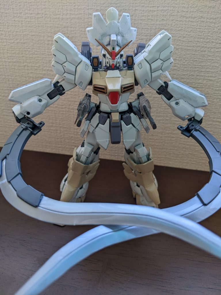 過去編イメージショット。最終形との違いはマスクのあるなしだけです。本当はジャンビーヤもないと思いますが、腰に装着しています。サンドロック作ると毎回「腰のこのでっぱりって何か接続する部分だよな~」と考えていたため、ジャンビーヤはこちらに装着。無加工でぴったりはまりました。やっぱりそういうためにあったんじゃんと(笑)頭の増加装甲は、旧1/100サンドロックカスタムの後頭部に肩アーマーの羽っぽい部分を、ライオンのたてがみイメージで接着し、白で塗装したものです。下腕の増加装甲も、旧1/100サンドロックカスタムの肩アーマーから、羽っぽい部分以外のところを組み替えて接着し、白で塗装しました。足の増加装甲はMGシュピーゲルのアンクルアーマーをベースに、内外のくるぶし部分に旧1/100サンドロック肩アーマーの残りの羽根部分を、前足首部分に肩の横垂れのパーツを接着し、サンドイエローで塗装しました。どの増加装甲もサイズぴったりなので、過去編、未完成辺と使い分けができるように作成できたのが嬉しい。