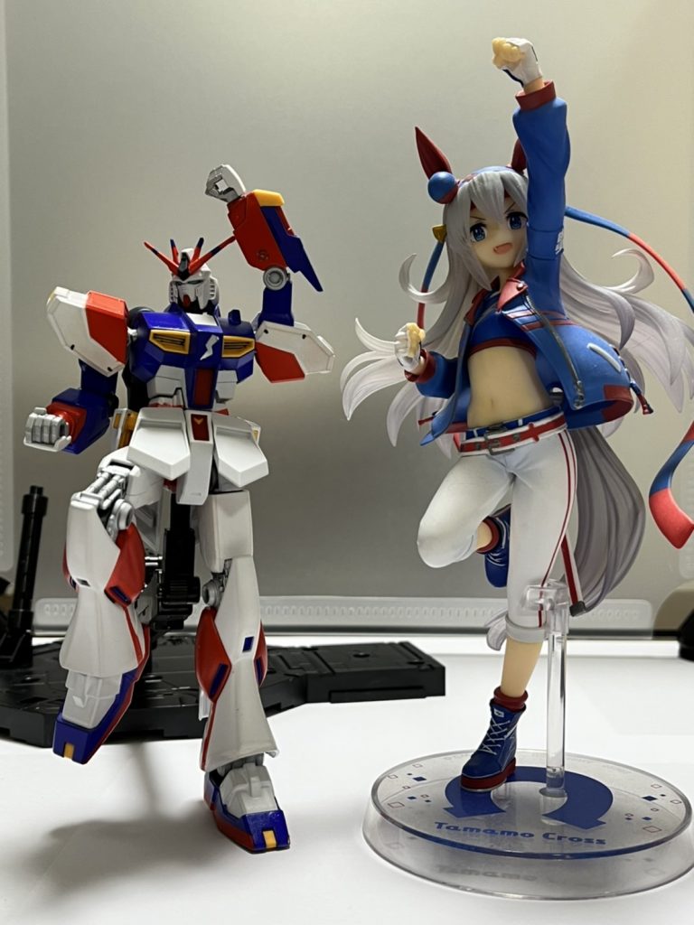 実際、ウマ娘を知らない方にもわかりやすく、並べて撮影してみました。見ての通りνガンダムの横で、可愛く、そしてかっこよくポーズして並んでいるのが、勝負服姿のタマモクロスです。イメージで塗装したわけではなく、タマモクロスの勝負服を見て塗り分けをしました。多少、違っている箇所がありますが、これは私自身が、「こっちの塗り分けのほうがかっこよく見えるかも…」と思い、あえて勝負服とは違う形で塗装しています。νガンダムのコックピットあたりの稲妻のマークも、この写真だとわかりにくいですが、タマモクロスの勝負服の胸付近に記されているマークです。マスキングテープで即席で型を作ったのですが、割りと上手くできていて満足しています!