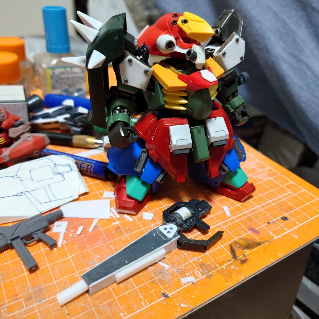 フロントアーマーをBB戦士サザビーのリアアーマーと百錬のナックルガードを使いそれっぽく。肩のバーニア基部はランドマン・ロディの足、右肩のシールドはHGUCギラドーガ。胸のフィンパーツはプラ板でうまく作れなかったのでHGギラーガのかかとを使用。二の腕は隙間隠しをプラ角棒で製作。ライフルは銃身がGNアーチャーでBB戦士サザビーのライフルやプラ板やジャンクと組み合わせて似てる風に。