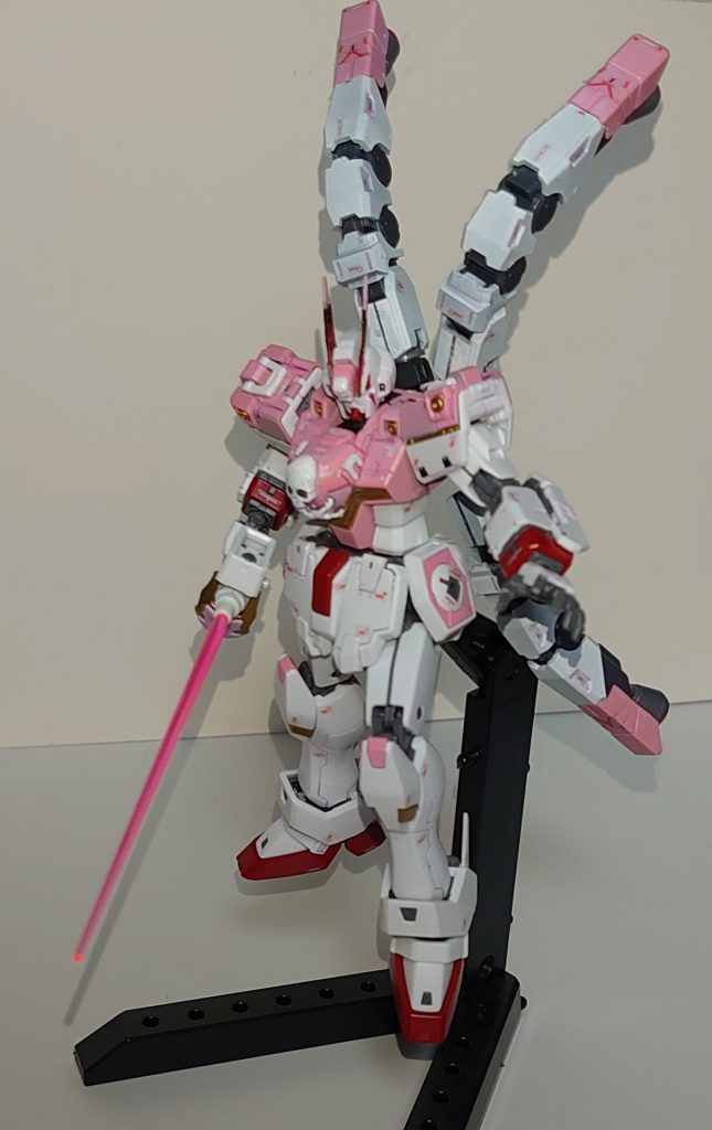 ABCマント無しで正面から。クロスボーン・ガンダムX-11を読んだ勢いで作りました。個人的にはお気に入りなのですが、漫画を読んでない息子からはピンクに塗ったのが不評でした笑。逆に読んだ人には見ただけでコンセプトが伝わってくれると嬉しいですね。バックパックのブースターユニットはコトブキヤのオーバードマニピュレータを加工して付けています。武器はザンバーの握りがそのままレイピアの握りっぽく見えたので、EGガンダムのビームサーベル先端を突っ込んでビームレイピア風に見立てています。アンテナは5㎜プラ板を切り取って接着。胸部ドクロはコトブキヤのレリーフセットを分割してパテで接着して加工してます。諸々の経緯は後述。