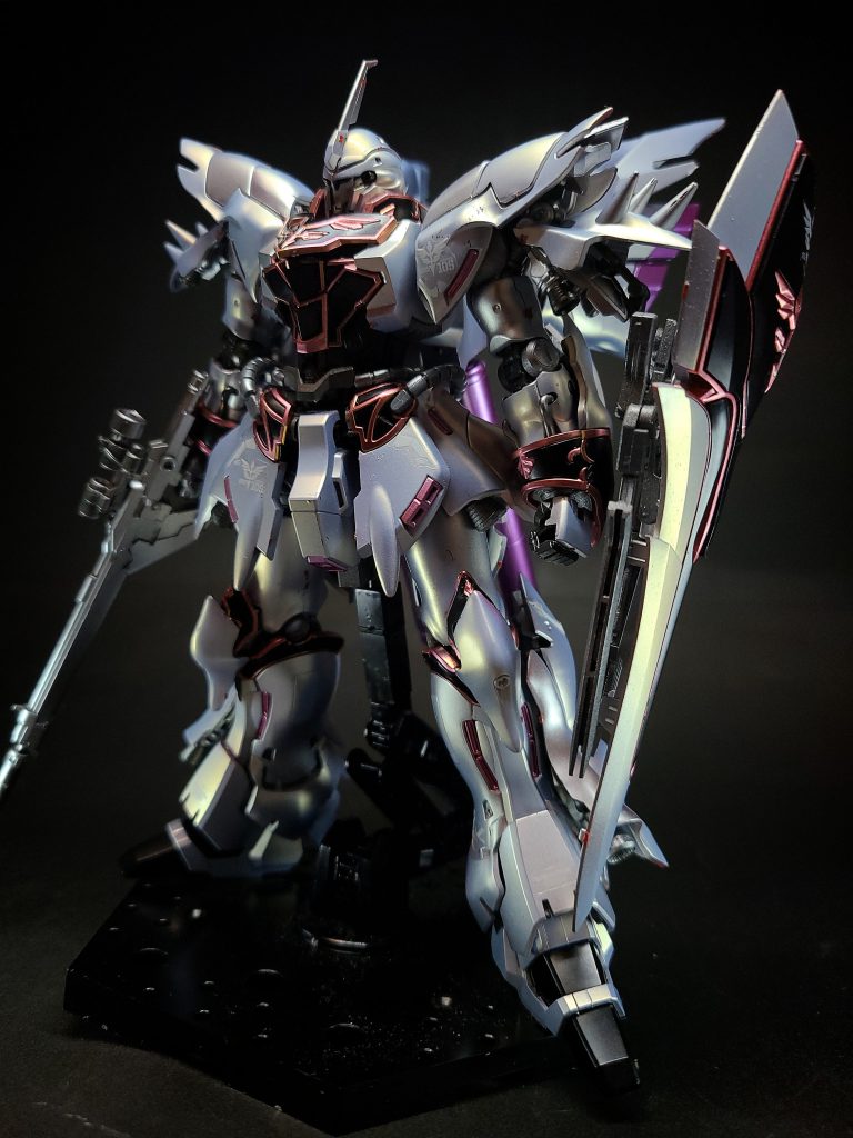 地球連邦宇宙軍再編計画「UC計画」の一環として、アナハイム・エレクトロニクスがサイコフレームの限界性能とデータ収集を目的に開発した試作MS「シナンジュ・スタイン」をネオ・ジオン残党軍「袖付き」が強奪し、これを改修し完全な実戦機体として完成させたものが本機体であるとされる。かつて同社が開発したMSN-04 サザビー、RX-93 νガンダムと同じく、機体の駆動式内骨格「ムーバブルフレーム」の一部にパイロットの脳波に反応する特殊構造材「サイコフレーム」を採用したニュータイプ専用機とされる[4][注釈 2]。サザビーなどと比べてスマートな体形なのは、技術進歩によるサイコフレームの多用化の実現によってサイコミュ装置の小型化が可能となり、それに伴って機体サイズの小型化が成功したためとされる。