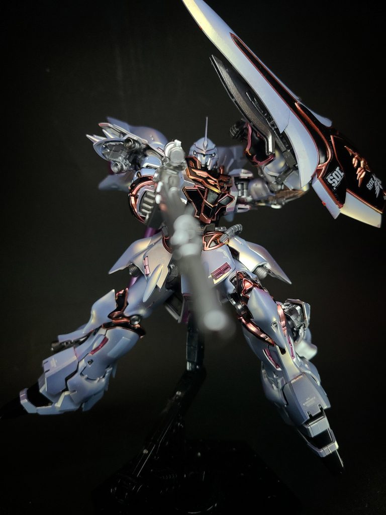 ユニコーンガンダムの「NT-D」発動時（デストロイモード）の実験機としての側面も持っており[2]、この機体（厳密には後述のスタイン）で検証されたデータを基にユニコーンガンダムが開発された経緯があり、そのことから同機とは言わば“兄弟機”の関係にあるが、宇宙世紀0094年にアナハイム社から「袖付き」に強奪（実際には強奪に偽装して譲渡）され、ユニコーンガンダムと刃を交えることとなる。強奪後は「袖付き」を象徴して率いるフラッグシップ機たるべく、全身の外装をジオン風に一新し、真紅の塗装と金色のエングレーブが施され、ネオ・ジオン軍のエンブレムをそのまま具現化したような[7]姿となった。この装飾は「袖付き」の雑多な勢力の寄り合い所帯をまとめる意匠であると同時に、シナンジュや親衛隊機、その他のエース機の当該部分にはガンダリウム系の新合金が採用され、一般機より装甲が強化されている[8]と設定されている。