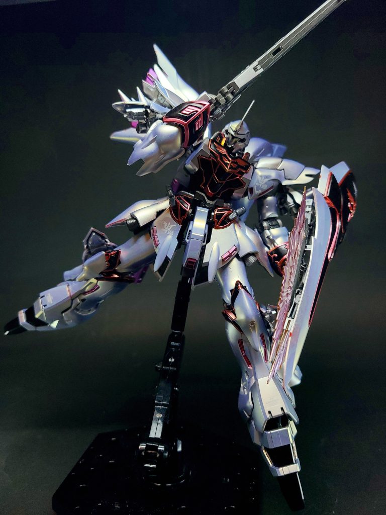 元々はサイコフレームをメインフレームに据えたMSの、一般パイロットの操縦では計測不可能な限界値を取得するべく、機械上での試験運用を目的とした実験機で、驚異的な機動力と追従性を誇るも、発生する加速度（G負荷）によるパイロットへの肉体的負荷は殺人的なレベル[注釈 5]で、なおかつインテンション・オートマチック・システム制御のサイコミュによる精神的負荷もあるため、並のパイロットにはまず乗りこなせない“極めて端的な[13]”MSであったとされている。その限界値を突き詰めた設計ゆえ、人間が乗り込む機動兵器としては欠陥機とも言えるMSであったが、実際には人を超えた「ある者」に向けて造られていたとされる。強奪に偽装した譲渡という形でネオ・ジオン残党軍「袖付き」の手に渡り、「赤い彗星の再来」と渾名され、ニュータイプとしてもMSパイロットとしても高い能力を誇るフロンタルが操縦することで、あくまで理論上であったそのポテンシャルを、作中の戦闘にて遺憾なく発揮することとなった。