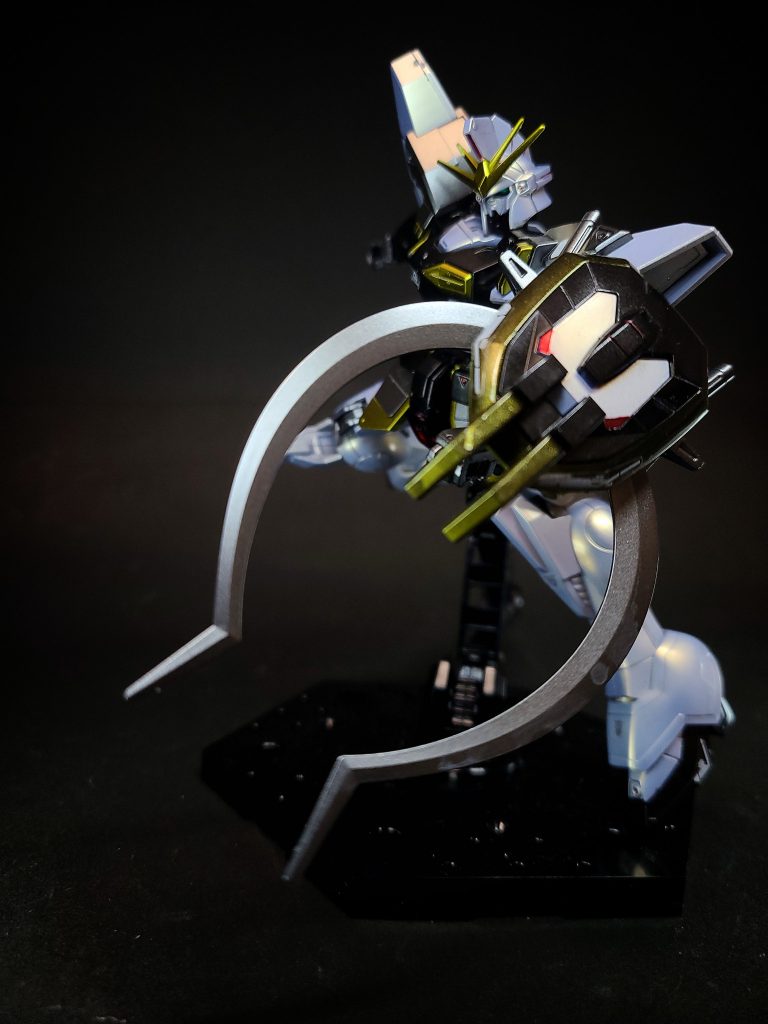 シールド（シールドフラッシュ）コブラの顔をモチーフにした、対ビームコーティング仕様のガンダニュウム合金製防御装備。表面には強烈な光で敵の目をくらます「シールドフラッシュ」機能が、先端部にはクローが備えられている[2]。