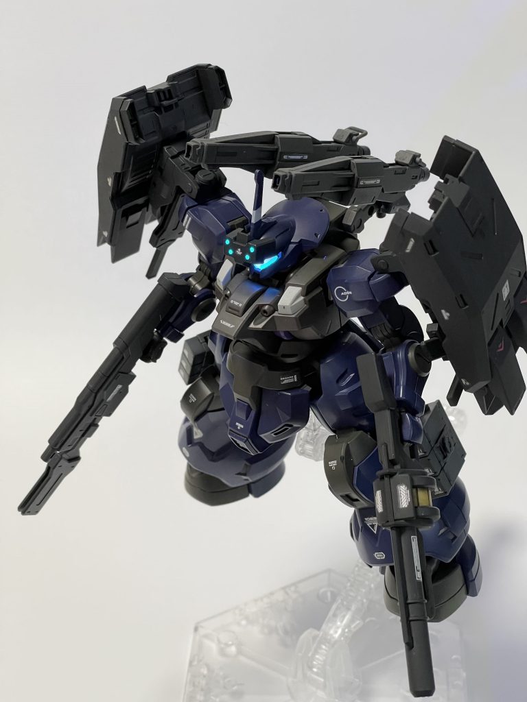 作例的なアピールポイントとしてはカメラアイの発光にこだわり。ディランザ一般機およびディランザ・ソルは紫と水色の二色構成なので蛍光レッドと蛍光ブルーの重ね塗りと蛍光ブルーグリーンの三色を利用して塗り分け、原作の表情を目指しました。額にあるバイザーの四つポチもしっかりと発光。キット付属のラウダ機用シールドをぶった切って接続用アタッチメントだけ切り出し、鉄血HGのゲイレールから流用したユニットに軸接続。キレイに無理なく接続が可能にフラウロス用ショートキャノン(鉄血オプションセットのやつ)、実弾砲にしては接続基部が華奢すぎるとか弾の入るスペースが不明とか気になる点があるのでビームキャノンに改装。発射口を形状変更してそれらしく。