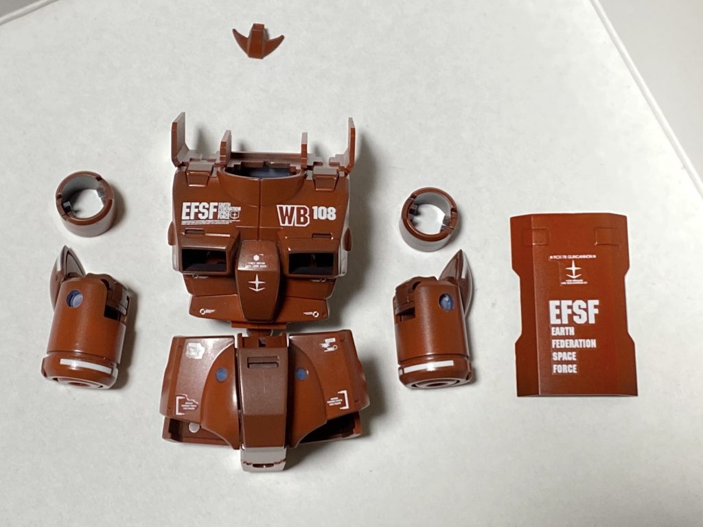 頭部、肩、各武器の合わせ目を消し、エアブラシで全塗装。今回はサフはあまり使わず、下地黒からのグラデ塗装です。武器類、肩、スリッパはメカサフスーパーヘビーをベースに調色。写真のベース塗装後にクリアブラック、クリアオレンジでエッジに煤感を追加。カーキ系を調色して下方から吹き上げて砂っぽくウェザリングしました。トップコートはツヤ消し。武器類、肩、スリッパは半ツヤ仕上げです。