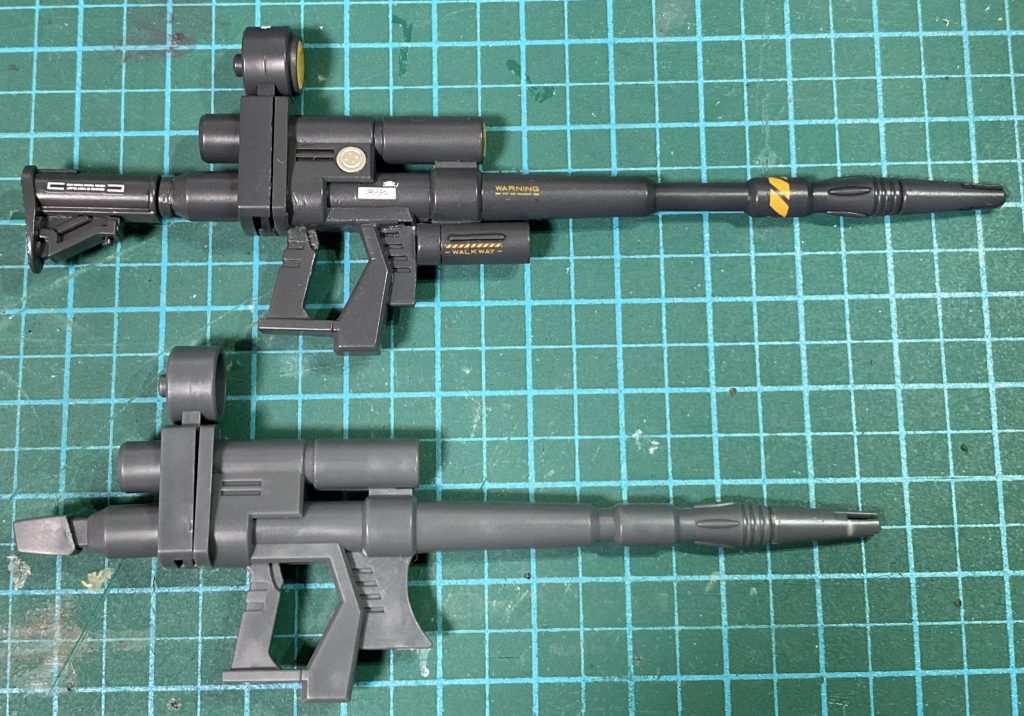 ビームライフルの改修前後です。バレルをカットし、3mmプラ棒に置き換えて1cm程度延長。後部の石突き？をカットしてシステムウェポンセットの伸縮するストックを接着。グリップを切り落として3mm後退、グレネードもウェポンセットから。スコープにサイトレンズを塗装して埋め込みました。