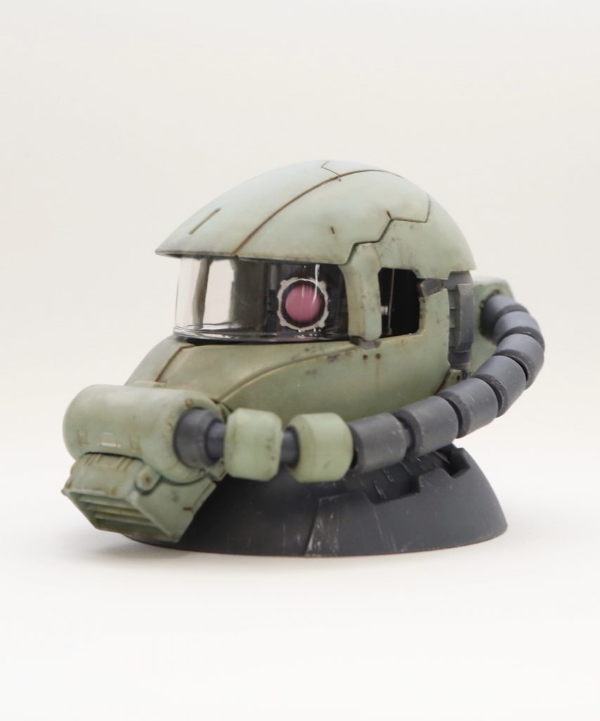 タミヤのウェザリングマスターAとB、ガンダムマーカーで汚してます。金属部分と台座は控えめなドライブラシ。これだけ汚れている機体ならバイザーも曇ってて然るべきですが、ただバッチくなってしまいそうな気がしたので綺麗なままで。パーツがずれているところはリベット穴を追加。このリベットでパーツ同士を繋ぎ止めてるイメージ。