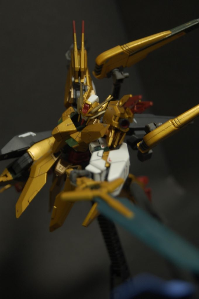 　本体の改修点は側頭部にバルバトスの耳などをつけ、頭頂部先頭とアンテナに少しプラ版をつけました。胸の黄色のパーツと腕のGNコンデンサーはUVレジンで複製したものと交換し100均シールを中に貼って、あとは胴体中央をそれとなくファルコンの顔っぽく見えるよう延長したくらいです。肩は30MMシエルノヴァ用のウイングを2枚重ねたもの、ヴェスバーは第6バルバトスのサイドアーマー接続部とバックパックをもぎったもので背中の機首にくっつけ、剣はダイバーエースのやつで一応機首にマウントできます。