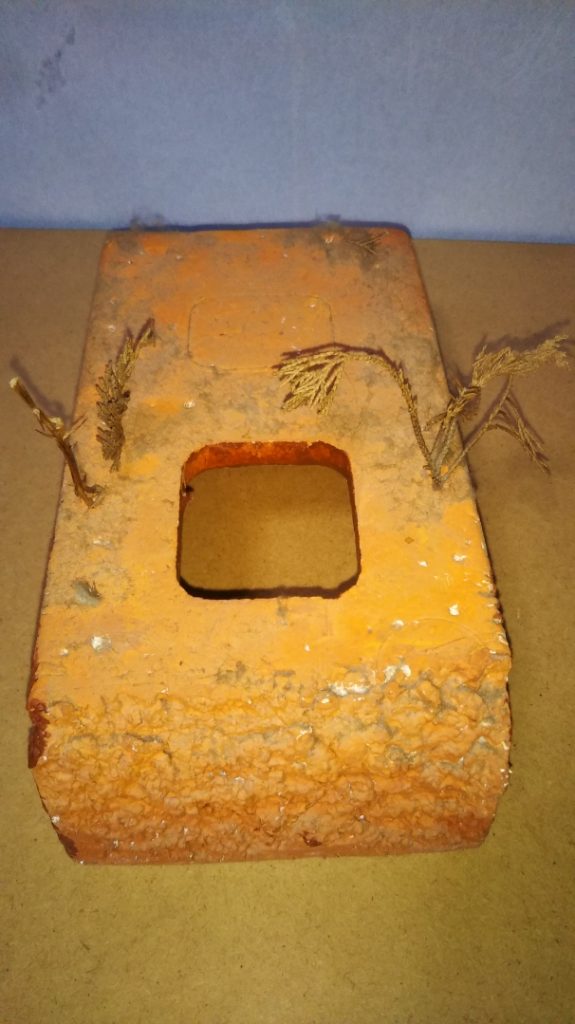 ジオラマベースです。 材料は中学生の頃に買ってもらった、電動鉛筆削りの入っていた梱包用の発泡スチロールです。 底面が2ヵ所、四角く穴が空くようになっていたので、その部分にモビルスーツを入れ、塹壕に下半身を埋めているようにディスプレイすることが可能です。 正面はカッターか何かで適当に削って崖を表現してみましたが、発泡スチロールのツブツブがいい具合に岩肌っぽくなってくれてなかなか臨場感が出たのではないかな、と思っています。 また、こちらもザクキャノン同様、長年棚の上に放置してあったせいでホコリが積もりまくっていますが、かえってそれが砂ボコリっぽくみえたので、あえてキレイにせずにそのまま撮影してみました。