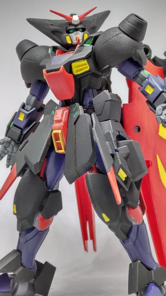 正面から。マスタ―ガンダム特有の威圧感はだしつつ、とはいえあまり悪役に寄ったデザインにならないように注意しました。イメージとしてはスパロボなんかによくある「東方不敗が味方についた世界観」で新たに乗り込むなんて展開で、ゴッドに対抗できるような新機体が用意されたら…なんて頭で組み合わせてあります。今回は黒サフ以外、ほぼすべて筆塗りにチャレンジしてみました。筆塗り難しいですね…。作品内ではMFは1回だけ変更（載せ替え・引継ぎ）できる…というルールなので、クーロン→マスターで変更してしまった東方不敗は「ゴッドに対抗する新機体」を登場させることができないため、今回は「～改」としてマスタ―ガンダムを再構築してみました。全体的な装甲を強化、運動性を維持するためのバーニアの増設などを行った「チャンピオンの正統的な改修機」として構築しています。