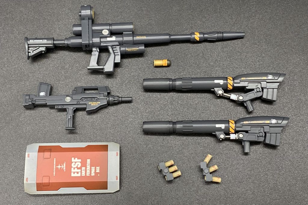 装備一式です。重い上に歩行移動のガンキャノンはキャタピラ移動のガンタンクより遅そうですが、呆れるほど硬いので、下手に動かず足を止めての狙撃が効率良いのでは？と考えました。ジオン垂涎のビームライフルは大気中では減衰するとの事なので、収束率を上げるためバレル延長、肩付けする為にストックを追加、射撃姿勢のバランスを見てグリップを後退、その分寂しくなった下部を埋める為にグレネードランチャーを増設しました。長いライフルは取り回しが悪いので、近接戦用のサブウェポンに初期型のサプマシンガンも携行。キャノンはディテール、説得力共に優れた初期型を選択。キットには1門しか付属しませんが、以前作成したミキシングではリバイブ版キャノン砲を選択したので、2門揃えられました。