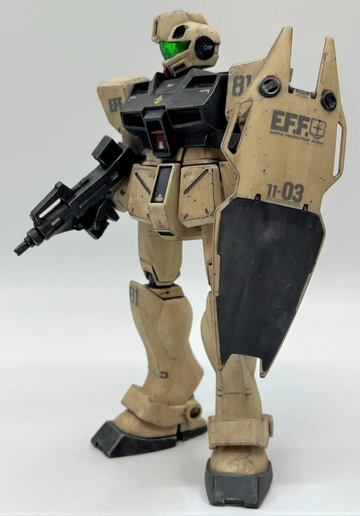 スミ入れはタミヤのスミ入れ塗料を使いました。スミ入れ、デカールを貼った後、アクリジョンのつや消しクリアを筆塗りしました。このつや消しクリア筆塗りが今回最もチャレンジしたかった要素です。つや消しクリアはあらゆる点で私のガンプラ制作手法では必須の工程ですが、スプレーかエアブラシを使うしかないと思っていました。ですが、一般的にはエアブラシ使い前提ですが、アクリジョンで瓶詰めのつや消しクリアがある事に気づきました。アクリジョンは一回乾燥させれば他の主要塗料溶剤に侵されづらいとどこかで読んだことがあったので、筆でムラが目立たず塗れさえすれば、手軽に無臭、しかも安価につや消しクリア処理が出来ると考えました。結果としては「まあ予想通りかな」と言えるレベルで仕上がりました。リターダーをつや消しクリアの瓶にスポイトで直にチューッと入れて乾燥を遅らせてみましたが、まあまあしっかり筆ムラは残りました。ただ、ムラが出るのは想定内で、その後のウェザリング工程でどこまで誤魔化されるのかが今回の山場でした。