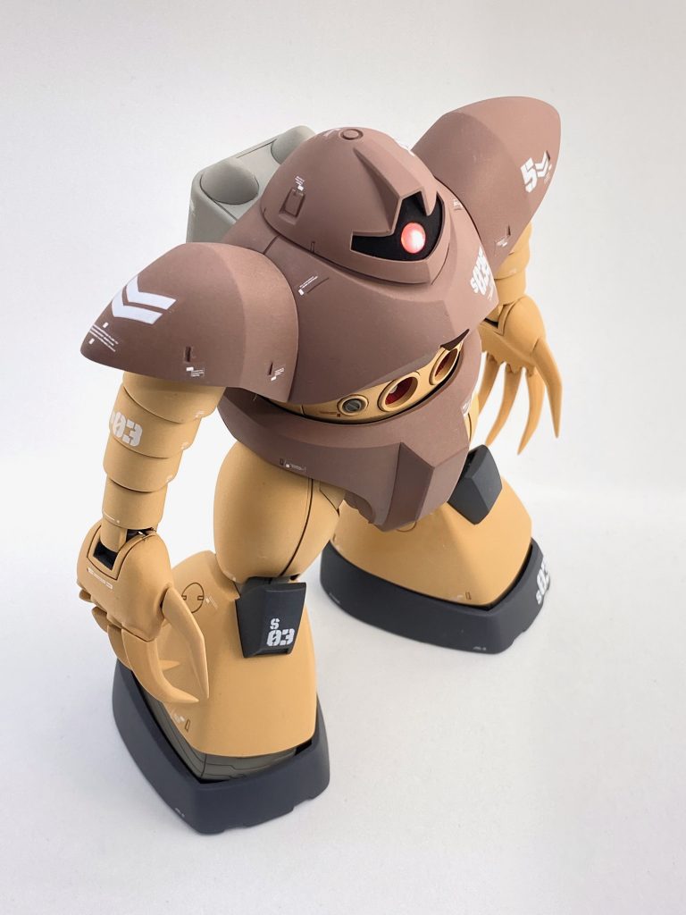 モノアイはアニメ版のイメージでディテール少なくグポンと光って欲しい……のでHアイズの下にメタリックシールを貼っています。基部が半球形なのでHアイズが飛び出さないよう、モノアイ大の穴を開けてハメ込み。レール部が天井を向いていて光を反射しがちなので、『黒色無双』で塗って真っ黒っぽさを出しています。