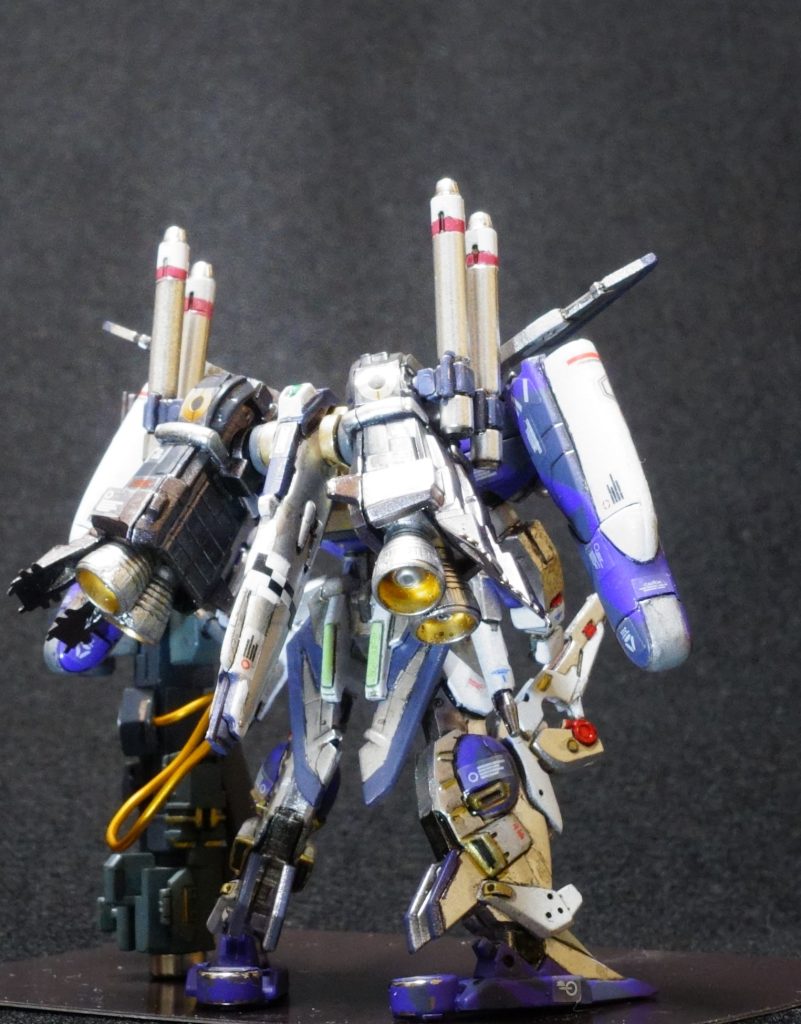 ●様々な運用シーンに単機で柔軟に対応できるイオタ・ガンダムのフレキシブルな設計思想から、2番機は戦艦の主砲レベルの火力を誇るバスターランチャーを、艦船にはありえない機動力を付した移動砲台といった特性が与えられた。●一年戦争時のジオンのビッグガンの高機動版とでも表現すべきか