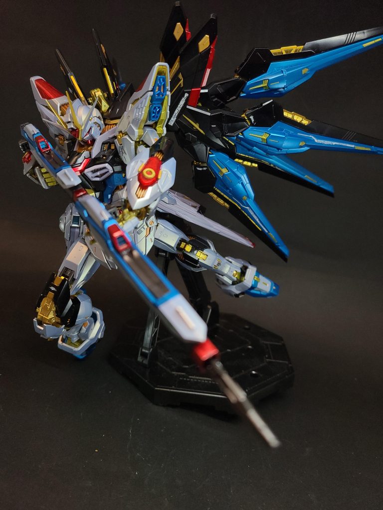 MGX-2235 カリドゥス複相ビーム砲腹部に内蔵された大出力ビーム砲。ZGMF-X31S アビスと同型の装備だが、ハイパーデュートリオンエンジンからのエネルギー供給により威力と連射性能は向上している[129]。固定装備のため機体正面にしか撃てないが、本機の搭載する武装の中でも特に高い威力、また構えずに撃てるため、乱戦などでは使い勝手が良い[112][130]。その砲口はフレーム同様の金色にフェイズシフトする。コックピット直下にこの兵装が搭載されたことに伴い、コックピットとの間を遮蔽する超高精度鏡面壁とエネルギー防壁が完備され、不測の事態からパイロットを保護している[112]。