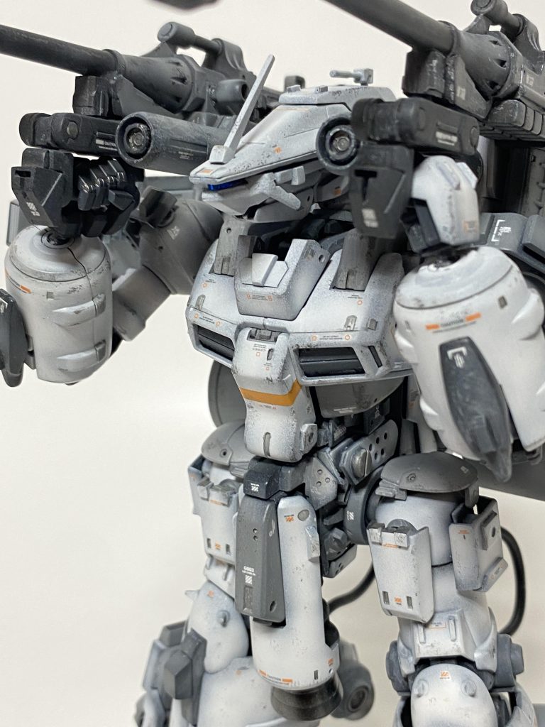 頭部アップで 高精度のセンサー類がまとめられた特殊な形状の頭部が装備されている。キャノンのグリップをマニピュレーターで固定することで、命中精度、連射能力を高めている。