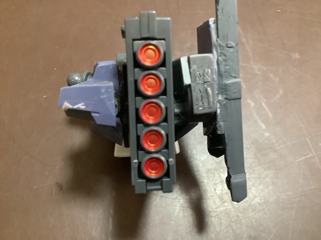 今度は胴体の後ろ側。RGかMGのユニコーンガンダムのバズーカのマガジンを赤に塗装。ヤスリがけを忘れていて表面が汚いですがそこはいいとして…（よくないけど）グレイズの肩を取り付け、グランドスラムを装備する部分も作成。装備する部分に使ったパーツは床に落ちてたよくわからんやつなので何を使ったかはわかりません。