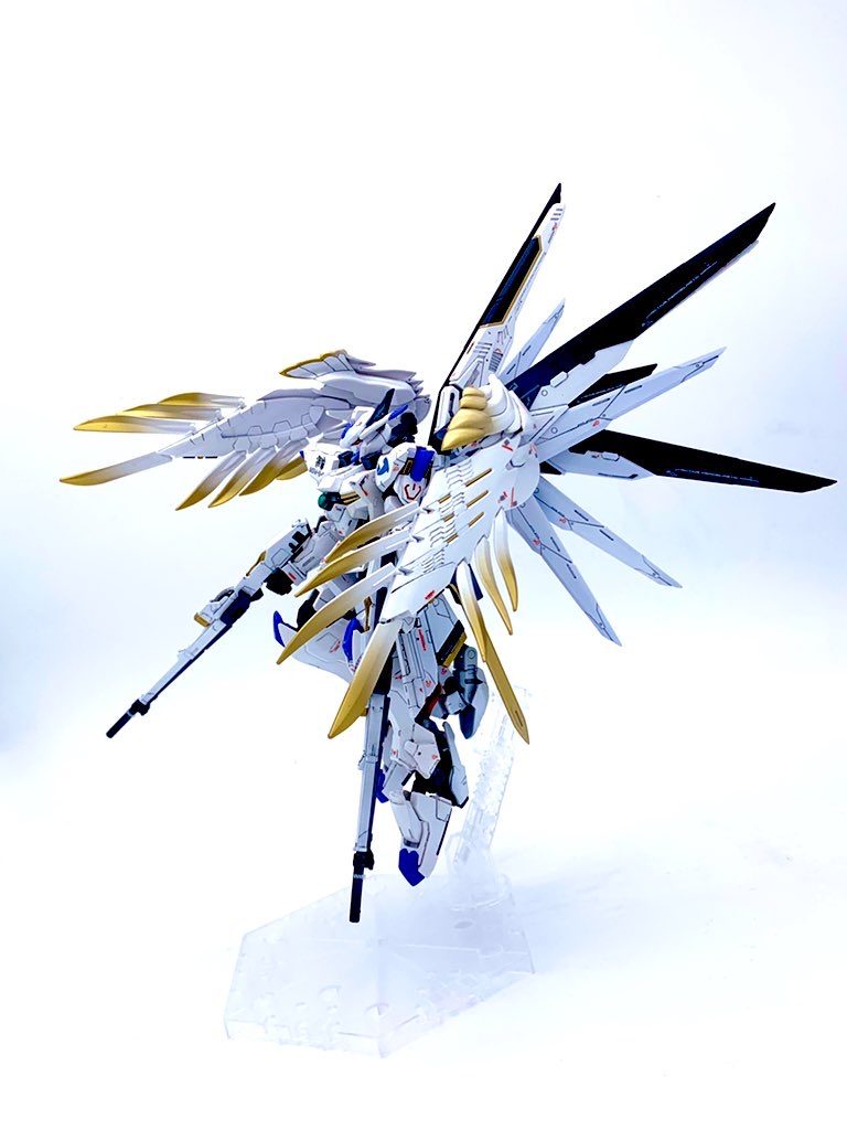 腰部にマウントしたバエルソードや羽、膝裏の隠し腕など、横から見ると全ての武装が見えます。ゼロのウイングバインダーは金のグラデーションを入れて少しエレガントに。フリーダムの羽は白を基調に塗り替え、濃く見える部分は青に偏光する塗料で塗っています。