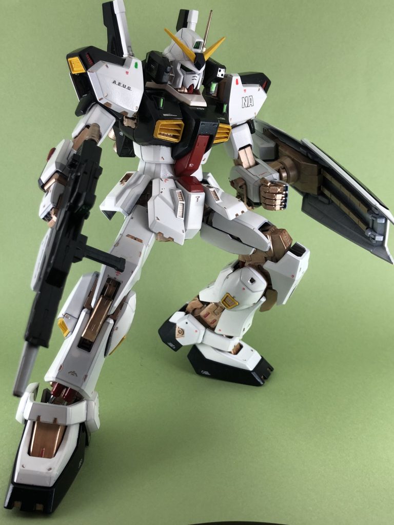 説明書のポーズ1です。以下、作成情報1500番の缶白サフを吹いて、白部分はそのままです。アクリジョン筆塗りメタルブラックの上にクリアブルーを重ね塗りフレーム関係はカッパー黄色はベースイエロー塗って、その上にイエロー赤はベースレッド塗って、その上にレッド白装甲のモールド部にもカッパーで墨入れがわりのアクセントをエナメル塗料筆塗り一部、シルバーや赤をエナメル塗料で部分塗装しています。水転写式デカールRGのマーキングを参考にありあわせで(境界戦機とかHIQパーツとかHG向けガンダムデカール)ちょっとだけ墨入れMrウェザリングカラーマルチグレーで顔とか色分けの部分とかに水性トップコートデカール前に光沢トップコート、デカールと墨入れ後にもう一度トップコートして、慣らしの意味も兼ねてメラミンスポンジであちこち撫でてなんとなく艶消ししています