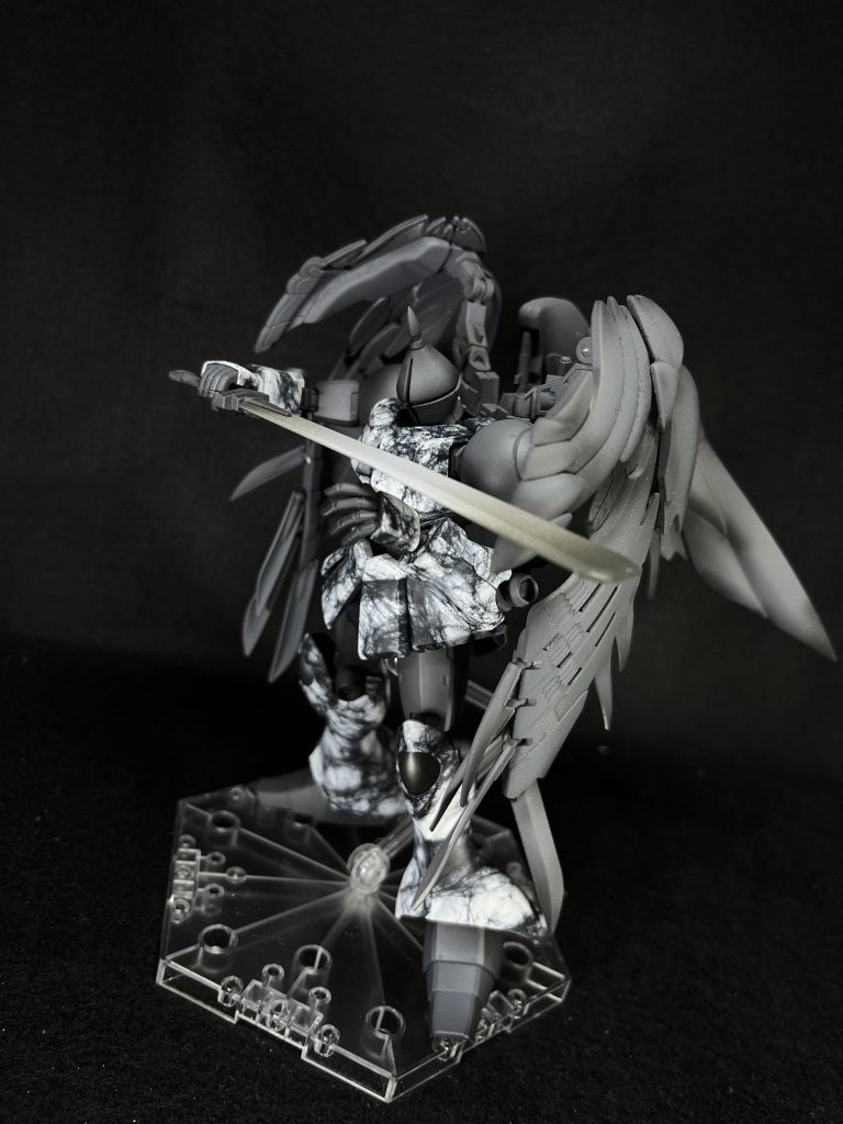 今回は塗装を頑張るがテーマだったのと、石像にいつものびっしりなディテールアップは似合わないと思い、改造ポイントは少なかったです①ミキシング　見たらわかるだろって話ですがRGのゼロカスの翼をバックパックごと付けています。ギャン背の穴に合わせてバックパックにも穴あけ、3mm丸棒で接続しています。②スタイル改修　かっこよく言ってますが顔のみです。顎を引けるよう顎を削ったのと、頭のてっぺんを尖らせたくらいでした。③武器のセミスクラッチ　グフのサーベルをもとにいわゆる処刑人が使うような先の尖っていない剣を作成しました。普通の灰サフと黒8、灰2のサフでグラデーションをかけてます。