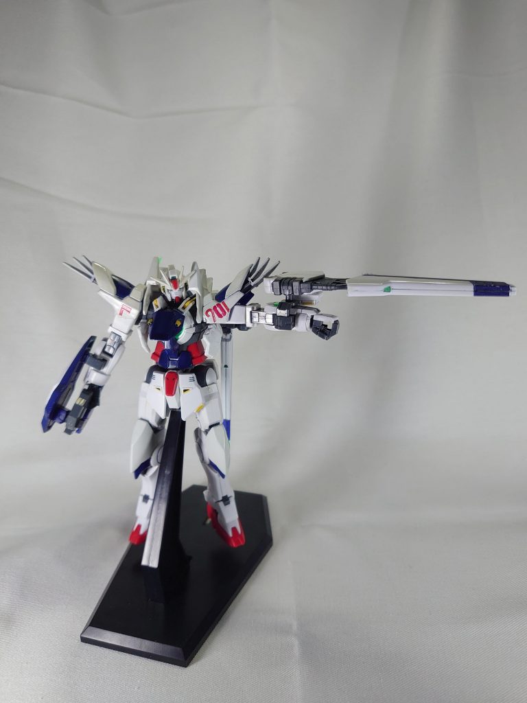 GNビームシールド複合兵装ユニットビームシールド、ビームライフルが複合された固定式兵装。圧縮したGN粒子を平面的に展開する事で、ビームシールドを形成。非常に高い防御力を得ている。粒子の展開範囲を調整することで、ビームサーベルとして扱うことも可能。距離を詰められてGNソードが使用できないという場面をカバーする。諸事情により、ヴェスバーとほぼ同じ機構を持つ為、ビームライフルとしての運用が可能。GNドライヴ直結のヴェスバーと比べて威力は劣るが、威嚇牽制用としては破格の攻撃力を誇る。当初の計画では、「GNフィールド」という機体全面を圧縮粒子が覆う防御兵装が考案されていたのだが、いざ開発してみると、圧縮粒子の展開が非常に困難であることが判明。GNヴェスバーの粒子圧縮機能と従来のビームシールド発生機を応用、複合する事でやっとビームシールドと同じ形に落とし込むことができた。計画は実現できなかったが、副産物として、火力を手に入れた。