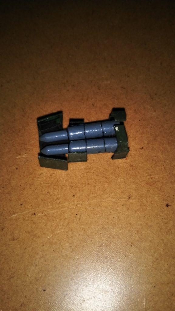 追加武装の大型ミサイルです。 ミサイル本体はプラ棒とMGゲルググのビームナギナタを適当な長さに切ったモノを組み合わせ、先端をとがらせて製作しました。 表のラッチというか装甲板の部分は、プラ板によるスクラッチです。 装甲板の上部を折り曲げて、左腕のシールド部分に引っ掛けて装備できるようになっています。 ちなみに塗装は、ミサイル本体がブルーグレー、装甲板(ラッチ)は水性ホビーカラーのグリーン、装甲裏はツヤ消し黒です。