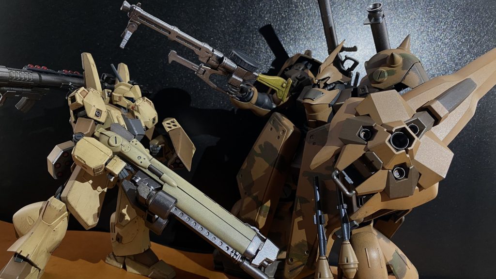 「クソッ、なんて奴らだ。この連中、手練れなんてモンじゃねぇ。一人一人がエース級だ」　強い。いや、そういうのともまた違う。俺だって一年戦争から戦ってきた、単騎で、部隊で、どんなに優れた個人だろうと、チームだろうと、誰かしら突出したりミスをしたりする。俺だってそうだ。だがこの連中はどうだ、誰もミスしない、突出しない、隙がない。大型のマシンガンと小型のマシンガンを持つ前衛二機、それ援護するバズーカ装備の二機、この四機の連携、攻撃はまるで精密な機械式時計のようだ。　だが、連中は俺の誘い乗ってくれた。この台地で俺を囲むように戦っている。これなら渓谷内の基地に影響はない、連中の攻撃を捌きながら、「林」の位置を確認する。そう、「林」。この台地の北側に広がる、大小様々なスペースコロニーの残骸が林の様に突き刺さっている場所だ。ここオーストラリアにコロニーが落ちた際、破片が雨の様に降り注いだ所だ。そして、この林を抜けた先は渓谷を抜けた先の道に続くのだ。「林」の中に、連中を誘い込めれば、自分がやられてもそのまま北上してくれる筈だ。まあ、やられるつもりもないが。　的確に、こちらの動きを止めてくるバズーカを避け、前衛二機の連携を捌きながら、攻撃と移動を繰り返す。こちらの機体性能は遥かに相手を上回っている筈、にもかかわらず、有効打を与えられないのは、林の方に誘い込む為もあるが、ジェガンタイプとは思えない程の厚い装甲、致命傷を与えられないのだ。　そんななか、急にジェガンの動きが変わる、走っていた機体が、滑る様に動き出したのだ。「ホバー機かよッ！」　 