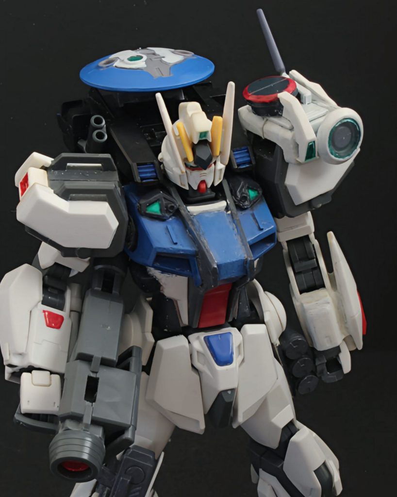  元の機体の仕様では､固定武装の多さのより機体の重量が増してしまい､それを脚部の大型スラスターによる加速力で補っていたが､本機では固定武装の撤廃,小型化を行い､また､脚部のスラスター類の改良により機体の軽量化を実現した 本機は戦闘目的で製造されていたが､改修に伴いパイロットがMSによる撮影活動を主にし始めたため､ガンカメラやレドーム等が搭載された偵察型のストライカーパックを装備している 撮影用のガンカメラの他､カメラユニットやロートドーム,強化アンテナ等搭載の複合情報処理ポット、大型のレドームやスモークディスチャージャー等搭載されたストライカーパックで構成されている