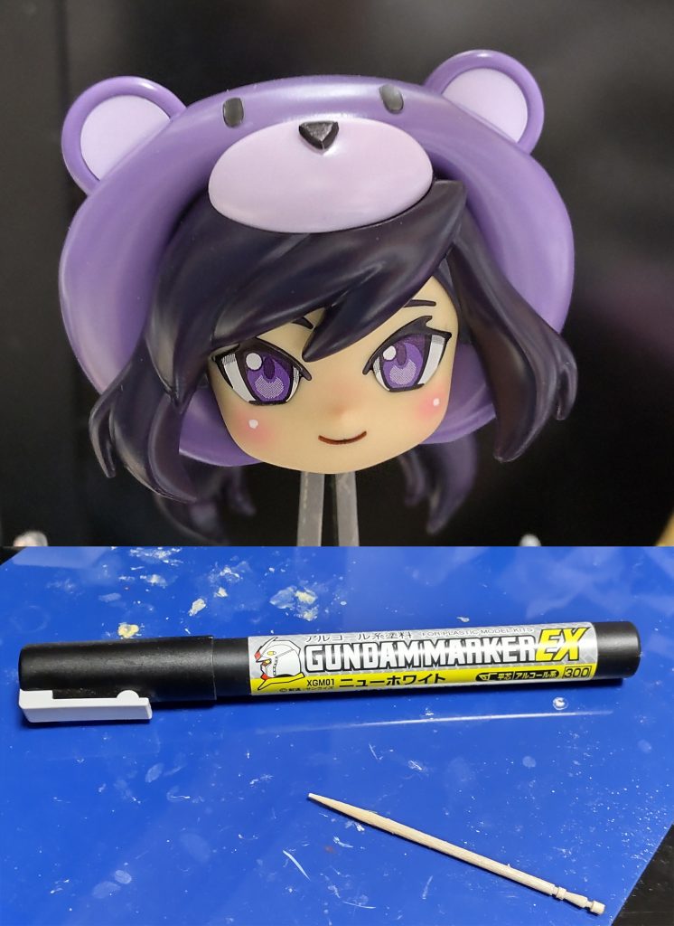 さて、今回のキモはこれ頬の中央(ちょい上?)にガンダムマーカーExホワイトをつまようじでチョンと乗せますこのハイライトがあると見栄えがずいぶんと引き立ちますよあとはつや消しトップコートで定着させますトップコートは目のシールを付けない状態でやらないと、目が曇ってちょっと勿体ないです