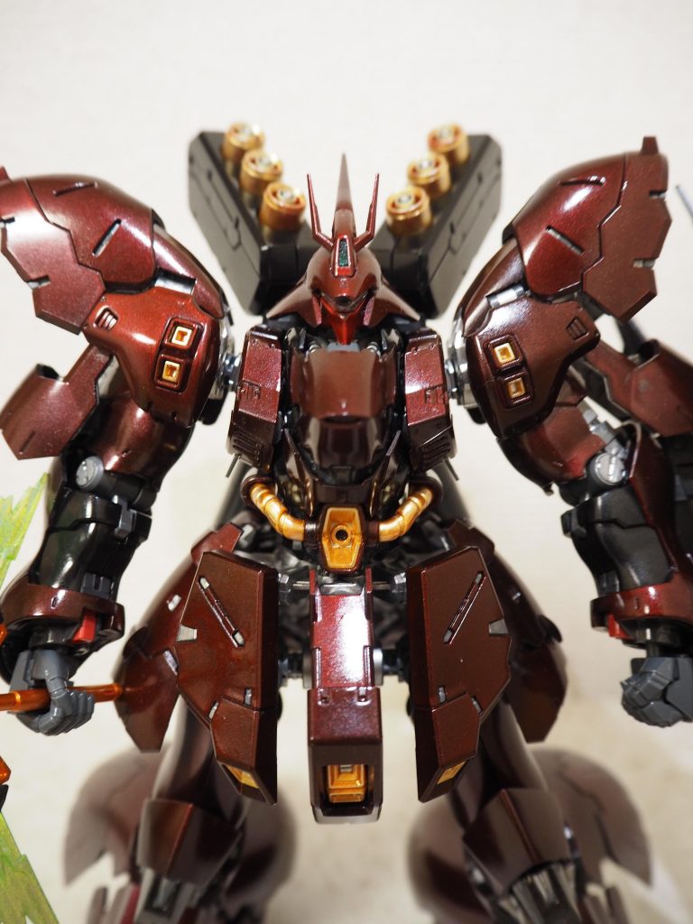 正面からのショットです。光を当てることでサザビー特有の美しい曲線の装甲が艶やかに光ります。この赤色を表現するためにキャンディ塗装のメタリックカラーの部分をダークステンレスにしております。（黒サフ→ダークステンれレス→クリアレッド）金色を各個箇所のアクセントとして配置したく、ファンネルのカラーも金色としました。