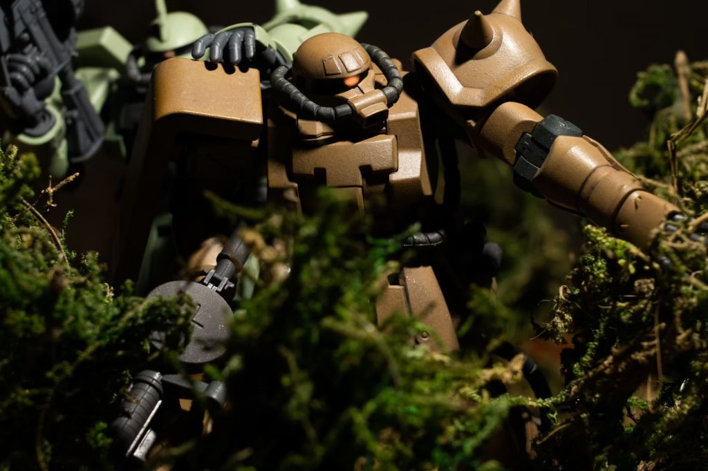 敵勢力圏への進攻してゆくザク小隊。生い茂るブッシュを掻き分けて進むポイントマンのザクを唐突に牽制する小隊長。「待て・・嫌な感じがする・・」まるで喉元が凍り付くような不快感ベテラン特有の理屈では説明がつかない勘が警鐘を鳴らし続ける。その刹那ブッシュを切り裂いて向かってくる凶弾が装甲をかすめ状況は一変する！制作テーマは泥臭い戦場をイメージ。