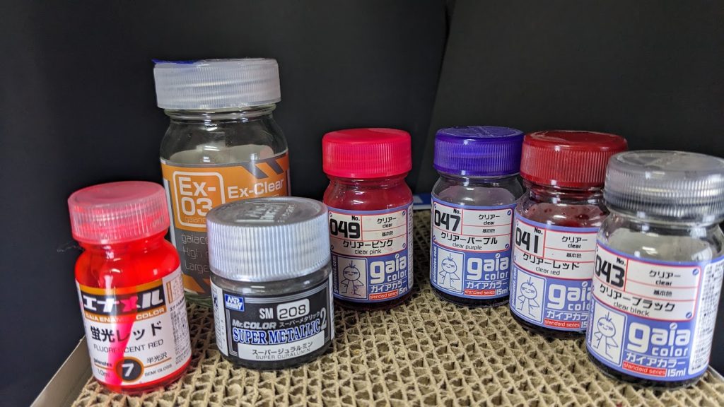 今回使用した塗料はこちら。サフは使わずにクレオスのスーパージュラルミンで下地を作ってガイアノーツのクリアを使いました。基本はジュラルミン→クリアブラック→クリアパープルで重ねてますが、キャンディならではということで、ブラックの回数をズラしたりクリアレッドやピンクを混ぜて塗り分けしてあります。前回サザビーを作った時に黒サフを下地にして実験したところ、色が黒くなり過ぎたりザラザラした質感になったのでサフレスでやりましたが、結果的に表面の傷が目立つので、完全な光沢目指すならサフ→光沢ブラック→シルバーの順で塗るべきかなと思います(エアプですが)個人的には鏡面にはならなかったけど、傷が逆に金属っぽさが出てこれはこれで味わいがあると思いました。