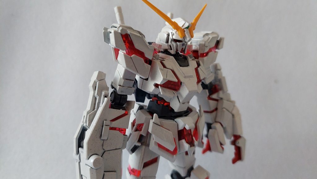 白黒のパーツを全部白で塗装するだけではつまらないし、ということでクレオスのホワイトパールを吹きかけ、きらびやかな白にしました。ただ、塗装が終わりスミ入れを、と思ったら口元のへの字型スリットが埋まっている! 考えてみれば黒サフ→白サフ×2→光沢ホワイト×2→ホワイトパール×3と合計8度がけしているのでさもありなん。後にうすめ液等でスリットが見えるところまで戻しましたが、このプラモではパーツ取り用に買ってあったフルコーンの口パーツで代用しています。余剰パーツの処分ではなかったのかとセルフツッコミ。他でもスジボリが甘くスミ入れできなかった箇所かいくつかあったり、落下してホコリがついてしまったりと以前作ったエクスヴァルキランダーほどきれいにはいきませんでした。