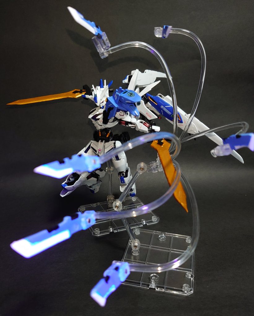 ガンビット「ラウンドソード」左肩に装備された本機専用のガンビット。本機のガンビットは剣と楯としての機能に特化しており、ビットオンフォームでは左肩に装備された対ビーム用のシールドとして機能、ガンビット時は刀剣型の遠隔攻撃端末となる。刀身にはフレームと同様の高硬度レアアロイが用いられており、敵機のビームを無効化しながら、質量兵器の実体剣が高速で四方八方から飛来するという、A.S世界のMSに対して驚異的なまでの攻撃性能を発揮する。本機最大のアレンジ装備です。やはり水星の魔女のGUND-ARMならガンビットは欲しいなということで追加してみました。形状や色はマクギリスが一期で身に着けていたスカーフ?マント?を参考にしています。(あとは中の人ネタでランスロットSINのコクーンの意匠も少し入っています)本機の装備であるエクスバエルソード、そしてラウンドソードから何となくお気づきの通り、アーサー王と円卓の騎士が隠し要素として各所に入っています。円卓の名を関するのに数が6本なのはパイロットのヴィトニルが人間としての「何か半分」を捨て去ってしまった為だとかなんとか・・。ヴィトニル・・いったい何ギリスなんでしょうね・・