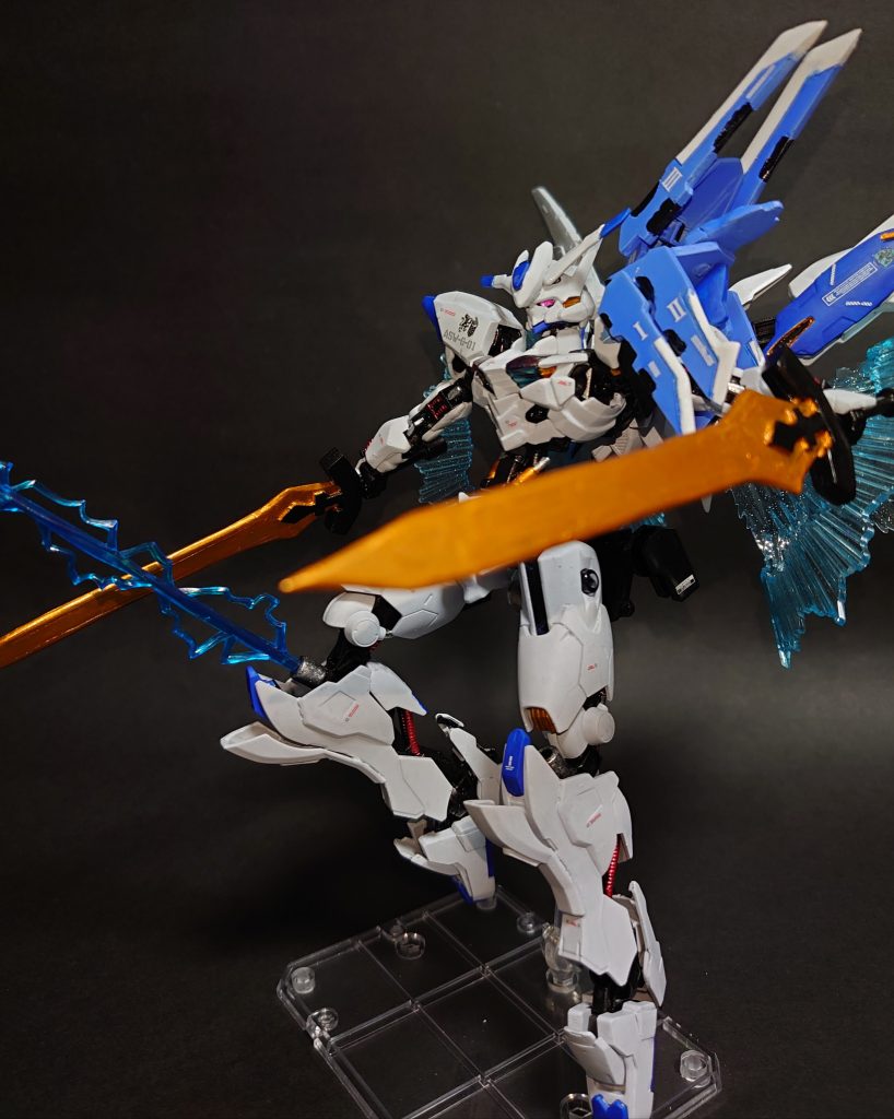 プラズマニードルガン膝部に一門ずつ収納されている。ファラクトのコラキに似た電磁ビームを打ち出す内装火器で、あちらが一対のガンビットを展開して網を張り巡らせていたのに対し、こちらは収束した電磁ビームを直接打ち出して使用する。本装備は命中個所の電気系統への攻撃だけでなく、パイロットへの直接攻撃も想定しており、サージ防御の脆い機体であれば一撃でパイロットを感電死させるだけの電撃量を放出する。位置の関係上、敵機との格闘戦になった際にコックピットを狙いやすく、また、敵の足回りを崩すのにも有効。特に脚部に機能が集中した機体に肉薄された際には絶対的優位を取れる装備である。バエルが腕に機能を集約していることを知っている人間であればなおのこと、意表を突いた決定打になりうる。さて・・何リスと誰リオのことなんでしょうね・・こちらは余っていた膝のスペースにアレンジとして加えた装備です。搭載位置といい名前といい、僕の大好きなガンダムAGE-1スパロー/Gバウンサーのニードルガンのオマージュです。基本的に両腕でバエルソードを扱うバエルにとって、自由に射角を取れる内装火器は重宝されると思い、追加してみました。※背中にベース機と同様のレールガンがありますが、水星世界では条約的に実弾が使いづらいので飛び道具はこれと下記の武装がメインになります