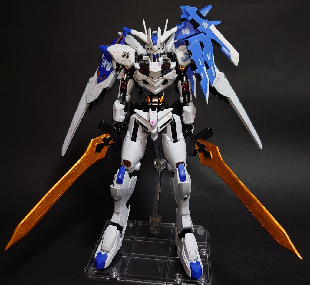 正面さて、今回の作品ですがちょうど第1クールが最終回を迎えた機動戦士ガンダム水星の魔女より主人公機ガンダムエアリアルをアグニカポイントあふれる機体に仕上げてみました。ガンダムエアリアルをベースにして頭部アンテナやスラスターウィング等、バエルの特徴的なパーツを移植しています。肩と背中、膝から下をガンダムフレーム4に置き換えた他、各部に鉄血風のディティールを加えてガンダムフレームらしく仕上げてみました。