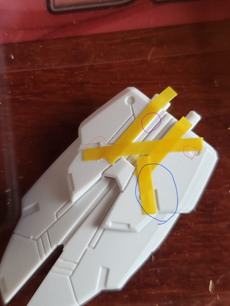 別キットのものになりますが、左右対称に彫る時はガイドテープの起点を決めます。この場合紫の線→アウトラインに沿って青の線→ディティールの中心辺りから平行になるよう赤の線→ディティールのカドと丸モールドの中心辺りを繋いでこれを行うことで左右対称にガイドテープを貼ることが出来ます。同じパーツを何個も彫る際はマスキングした状態を撮影しておくと位置を忘れずに済みますね!ちなみにマスキングテープは【HGマスキングテープ】をメインに使用しています。