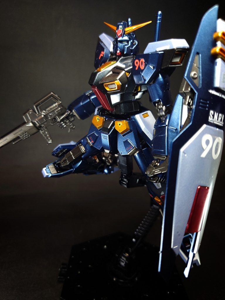 サナリィの技術担当重役であるジョブ・ジョンのもとに結成された開発チームに、AE社や木星支社から招聘した技術者グループを加え、チーフ・デザイナーにアルマイア・グッゲンバイガーを据えたメンバーによって開発がおこなわた、同年9月に1号機がロールアウトする10月にコンペティションがおこなわれ、1次審査の設計データをもとにしたコンピューター・シミュレーションでは、最大出力と対弾性ではMSA-120が勝るものの、運用コストや機動戦力比などではF9が上回り、総合性能でも高ポイントを獲得。そして2次審査のテストベッド同士による模擬戦においては、機動性の上回るF9が圧勝して審査官に大きな感銘を与え、選定される。