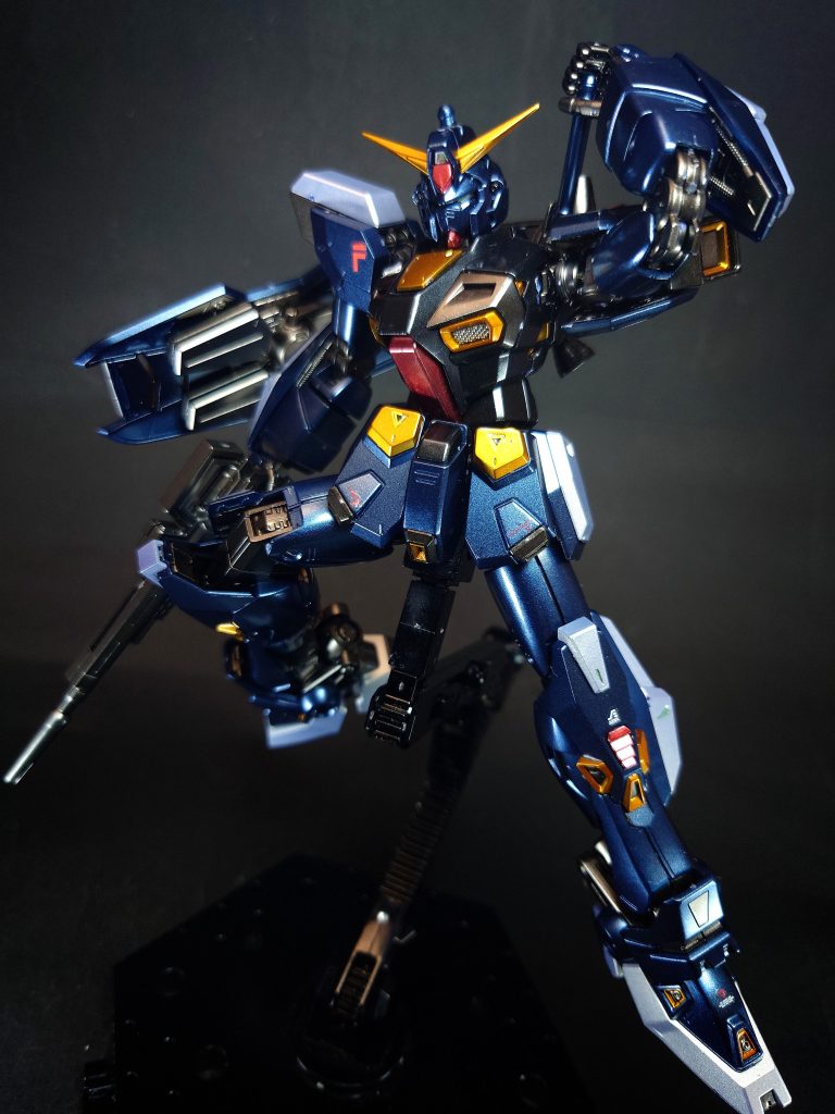 機体構造本体グッゲンバイガーの「MSの原点に戻る」という思想のもと、内蔵火器などMSの基本動作に必要のない装備等をいっさい排除し（のちに自衛用のバルカン砲のみ復活）、必要最小限の素体として設計される。これにより極限まで小型軽量化され、MS本来の高機動性をもつ機体となっている[14]。さらに、必要に応じてフレキシブルに装備を選択し外装するミッションパック方式を採用することで、デッド・ウェイトとなる装備をもたず本来の機動性を維持できるうえ、新型兵装を追加装備の設計のみで簡単に採用が可能となっている。同方式では可変MSのような単体全領域対応能力はもてないが、主力MSが支援なしに単騎で多領域戦闘をおこなうことはありえないとして了承される[14]。メインテナンスや稼働率を考慮すれば要求を十分に満たしており、規格の統一により機体の再調整はいっさい不要である