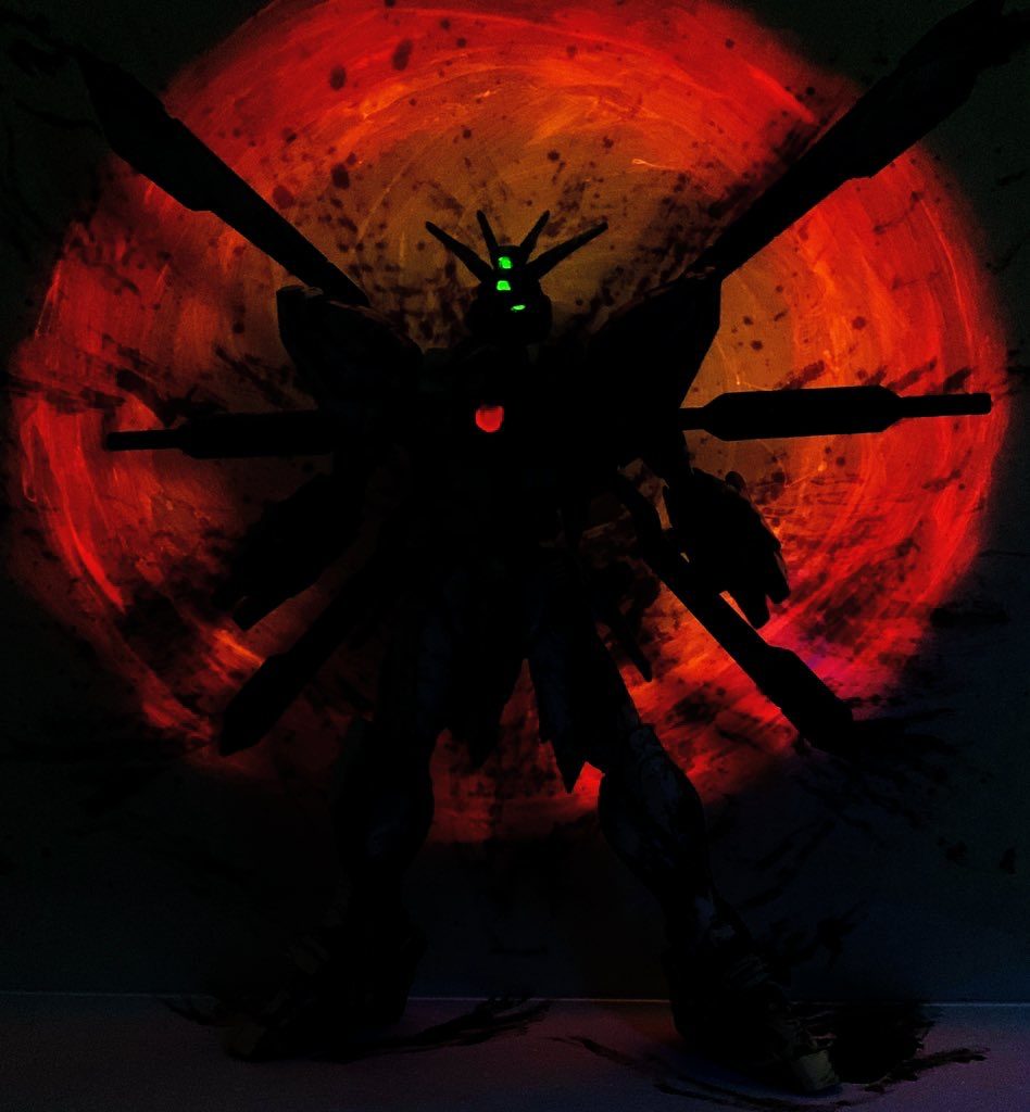  蛍光塗料をカメラアイや胸のコア部分、そして背景にも塗り、ブラックライトで発光するようにしています。RGゴッドガンダムに付属する日輪パーツはあえて使わず、背景に蛍光塗料で日輪を描き込むことで発光時に浮かび上がるようにしました。